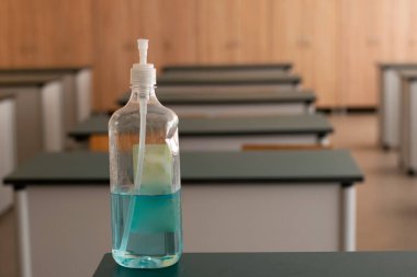 Bottle of disinfectant on the table in the classroom