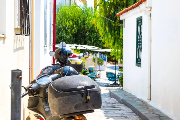 scooters and helmets parked in a white street