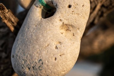 İpinde delik olan bir taş.