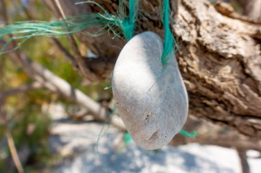 Bir. Yeşil bir ipte taş