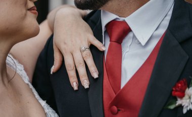 Gelin ve damat beyaz bir takım elbise ve bir buket çiçekle