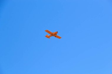 Mavi gökyüzü arka planında turuncu bir uçak
