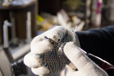 Erkek eller matkabın içine matkap sokuyor. Marangozluk işi.