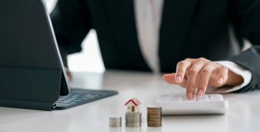 Businesswoman using calculator  to calculate real estate investments. 