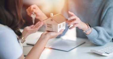 Close-up shot of a real estate agent or realtor meeting with her client, giving new house to her customer.