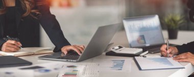 Bir grup iş adamı ofis masasında iş stratejisini tartışıyor..