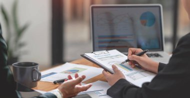 İşadamı danışmanı, iş adamları konuşuyor, planlama yapıyor. Tabletteki yatırım ve pazarlamayı analiz ediyor..