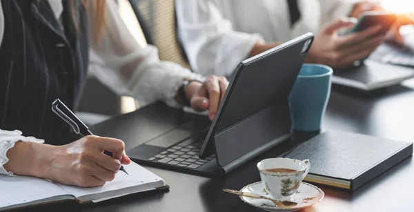 Business people working on tablet computer and document on her desk, planning and discussing on new project together at office.