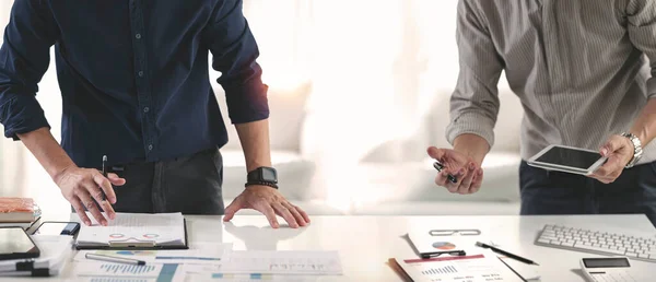 Businessman advisor, two business people talking, discussing, planning analyze investment and marketing on tablet in office.