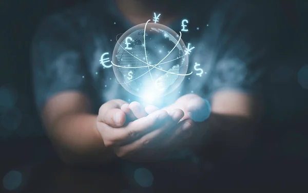Trader hands holding virtual word with currency symbol include US dollar Yuan Yen Pound sterling and Euro for global forex and currency exchange concept.