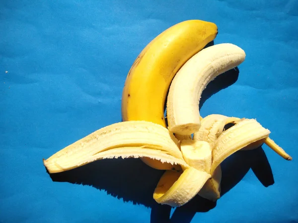 bananas on a blue background.cold tone.Classification of bananas Kingdom Plantae, Division Magnoliophyta, Class Liliopsida, Order Musales, Family Musaceae, Genus Musa, Species Musa paradisiaca