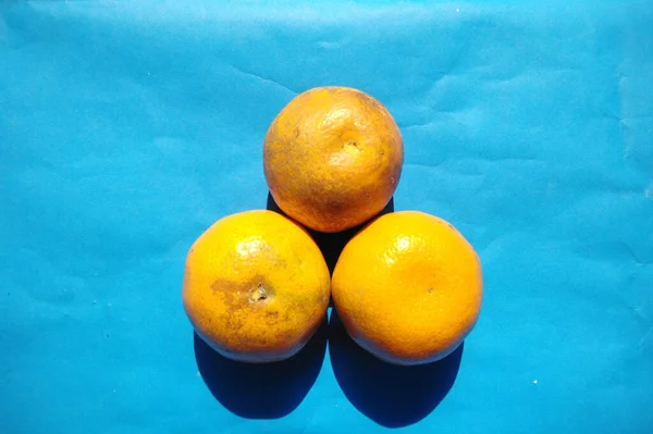 orange on a blue background.high angle view.cold toneOranges are native to a region that includes Southern China, Northeast India, and Myanmar, and the earliest mention of sweet oranges is in Chinese literature in 314 BC.