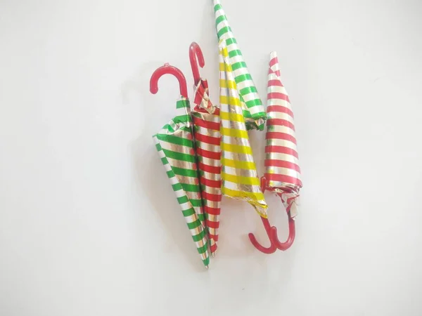 chocolate shaped like an umbrella wrapped in aluminum foil with a strip motif. isolated on a white background.close up.