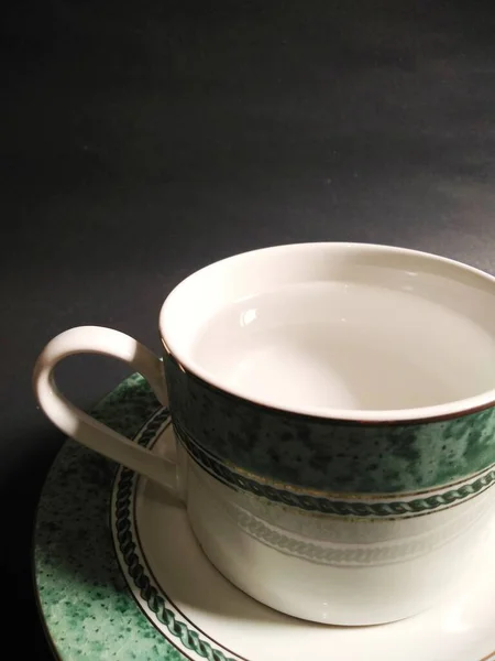 Siyah arkaplanda maden suyu dolu çay fincanı