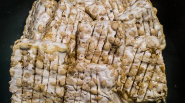 Pişirilmeye hazır, baharatlı bir kasede, bir kutu şeklinde işlenmiş çiğ tempeh.