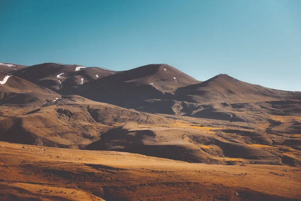 Orange mountain range landscape under blue sky. Highland alpine autumn meadow hill slopes. Wonderful picturesque scene. Wild nature. Stunning natural background. Tourism, travel concept