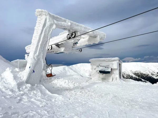 Ski resort chair lift station in high top mountains. Snow weather, frost, ice. Incredible winter landscape. Travel, sport, recreation