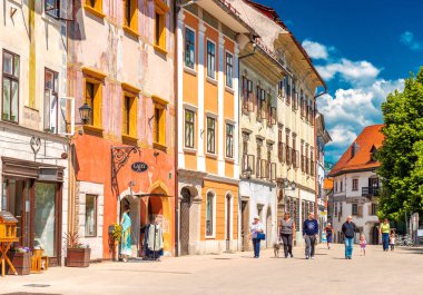 Skofja Loka - Haziran 2020, Slovenya: Eski tarihi binalar boyunca yürüyen insanlarla ana caddenin manzarası 