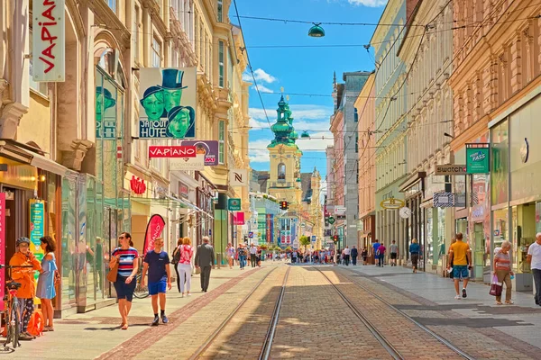 Linz - Haziran 2020, Avusturya: Yürüyen insanlar, dükkanlar ve tramvay hatlarıyla şehrin ana caddesine bakın