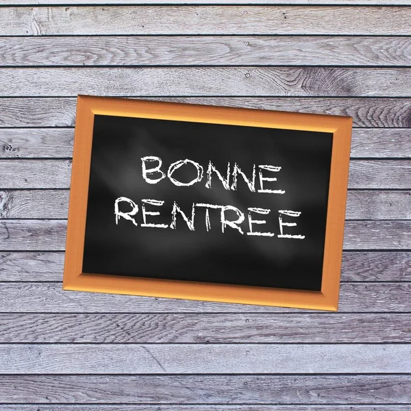 Back to school chalked in French on a school slate with a light wooden background