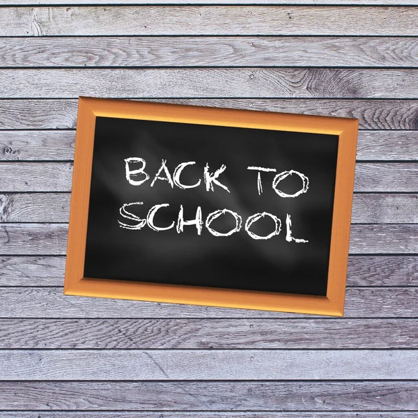 Back to school chalked in English on a school slate with a light wooden background