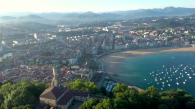 Unique cinematic perspective of the European city SAN SEBASTIAN. Situated in Spain -Vesque Country is a famous travel destination. Drone rotating around the Statue of Jesus. Panoramic view of the city