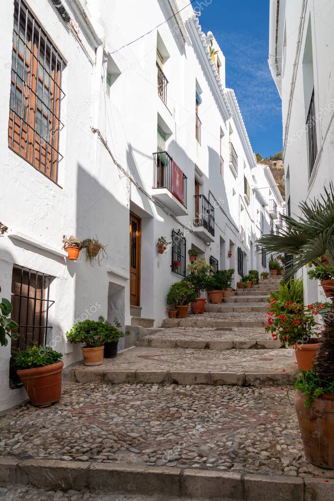Streets of Frigiliana village. Beautiful white houses and small streets. Typically Andalusian town. Touristic travel destination on Costa del Sol. Vertical photography.