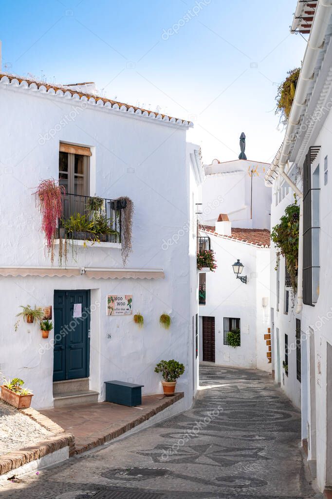 FRIGILIANA, SPAIN - January 28 2022:Streets of Frigiliana village. Beautiful white houses and small streets. Typically Andalusian town. Touristic travel destination on Costa del Sol. Vertical photo