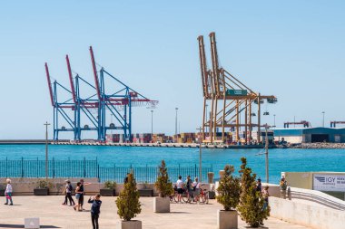 Malaga, İspanya - 21 Nisan 2022: Malaga ticari limanının görüntüsü. İnsanlar manzaraya hayran ve fotoğraf çekiyor.. 
