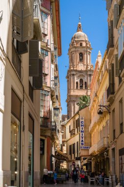 Malaga, İspanya - 21 Nisan 2022: Malaga sokakları. Eski Malaga küçük caddeleri, dükkanları ve restoranları olan gezinti alanı. Arka planda Malaga Katedrali 'nin güzel kuzey kulesi. 