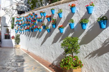 Aralık ayının güneşli bir gününde Marbella şehrinin güzel eski kasaba merkezi. Mavi saksıyla süslenmiş beyaz duvar.