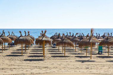Marbella 'daki boş plaj, İspanya' nın güneyinde, Costa del Sol. Sahilde kimse yok. Güneşli bir gün. Kum, sahil şemsiyeleri, Akdeniz.