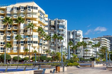 Marbella şehri şehir körfezi yakınlarındaki gezinti alanı. Boş kare. Arka planda Marbella sahilindeki evler, lüks ve pahalı gayrimenkuller. Palmiye ağacı, mavi gökyüzü