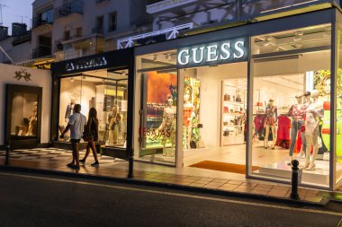 Marbella, SPAIN - July 16 2020: Night photography in luxury and famous location of Marbella -Puerto Banus  Bay. View of GUESS Store, in the shopping area of the harbour. Costa del Sol - Malaga