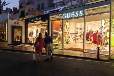 Marbella, SPAIN - July 16 2020: Night photography in luxury and famous location of Marbella -Puerto Banus  Bay. View of GUESS Store, in the shopping area of the harbour. Costa del Sol - Malaga