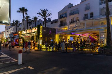 Marbella, SPAIN - July 16 2020: Puerto Banus Harbour in Marbella City. One of the most expensive and exclusive area of Marbella. Night photography of the night lifestyle with shopping area and bars