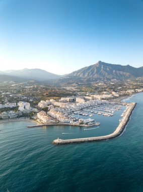 Aerial drone perspective of beautiful sunset over luxury Puerto Banus Bay in Marbella, Costa del Sol. Expensive lifestyle, luxury yachts. La concha mountain in background. Nueva Andaluca area