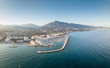 Aerial drone perspective of beautiful sunset over luxury Puerto Banus Bay in Marbella, Costa del Sol. Expensive lifestyle, luxury yachts. La concha mountain in background. Nueva Andaluca area