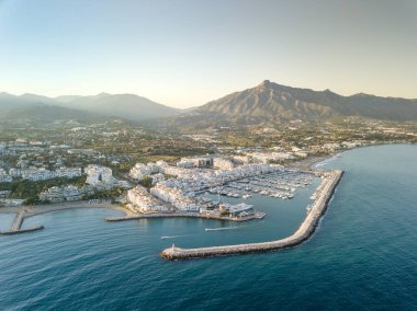 Aerial drone perspective of beautiful sunset over luxury Puerto Banus Bay in Marbella, Costa del Sol. Expensive lifestyle, luxury yachts. La concha mountain in background. Nueva Andaluca area