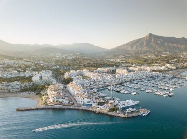 Aerial drone perspective of beautiful sunset over luxury Puerto Banus Bay in Marbella, Costa del Sol. Expensive lifestyle, luxury yachts. La concha mountain in background. Nueva Andaluca area