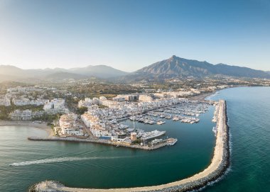 Aerial drone perspective of beautiful sunset over luxury Puerto Banus Bay in Marbella, Costa del Sol. Expensive lifestyle, luxury yachts. La concha mountain in background. Nueva Andaluca area