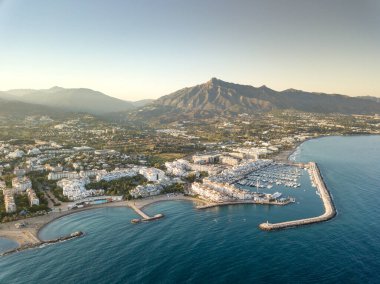 Aerial drone perspective of beautiful sunset over luxury Puerto Banus Bay in Marbella, Costa del Sol. Expensive lifestyle, luxury yachts. La concha mountain in background. Nueva Andaluca area
