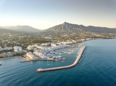 Aerial drone perspective of beautiful sunset over luxury Puerto Banus Bay in Marbella, Costa del Sol. Expensive lifestyle, luxury yachts. La concha mountain in background. Nueva Andaluca area