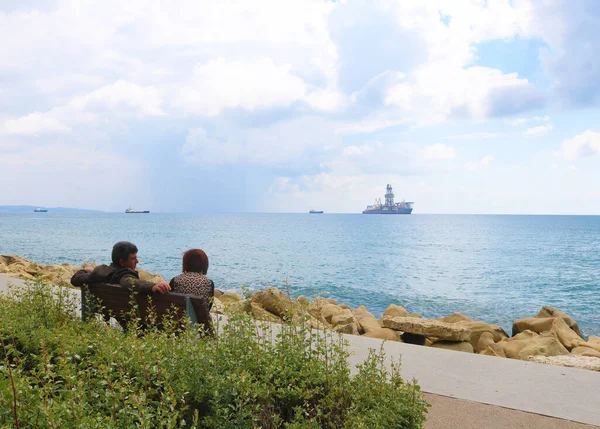 Cyrus 'ta sahilde oturan bir çift.