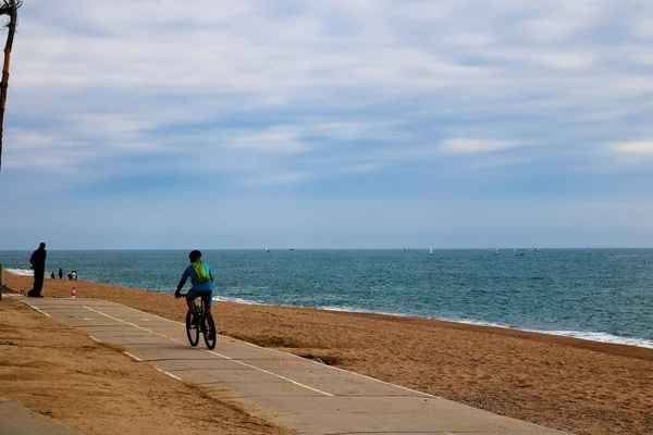 Sahilde bisiklet süren bir adam.