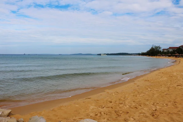 Deniz dalgaları ve mavi gökyüzü olan güzel sahil