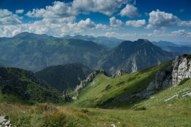 beautiful mountain landscape with green meadow and clouds