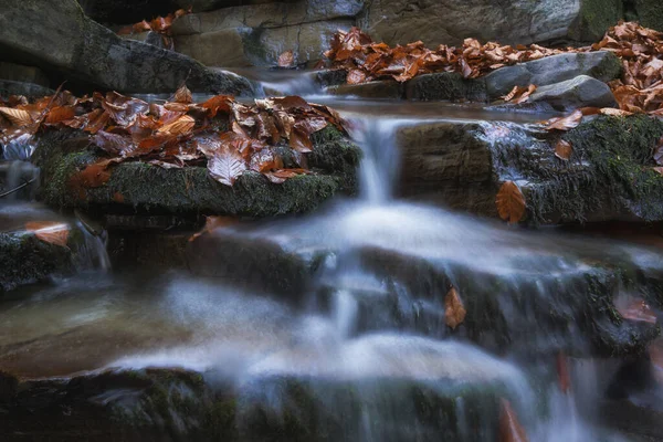 water flows through rocks, waterfall