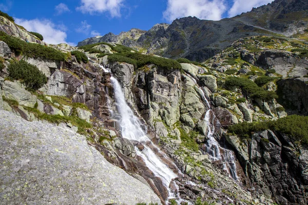The beautiful view of mountain waterfall Skok (vodopad Skok, Vysoke Tatry), located at High Tatras in Slovakia. Majestic Waterfall in Natural Landscape. Green background HD. Perfect wallpaper 4k.