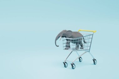 Hediyelik eşya dükkanında. İçinde mavi arka planda bir fil figürü olan alışveriş arabası. 3 Boyutlu Hazırlama.